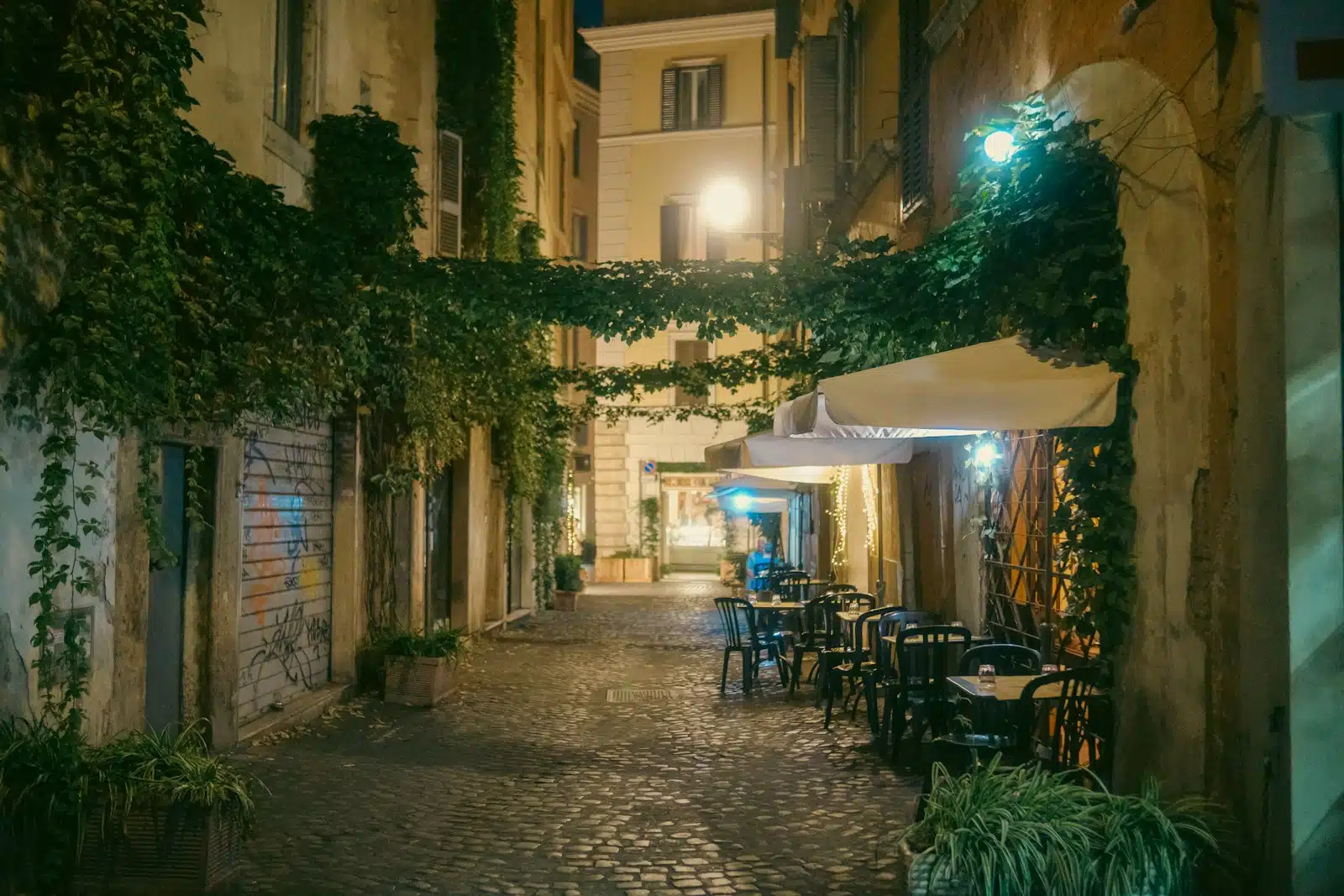 trastevere a cobblestone street with tables and chairs at night