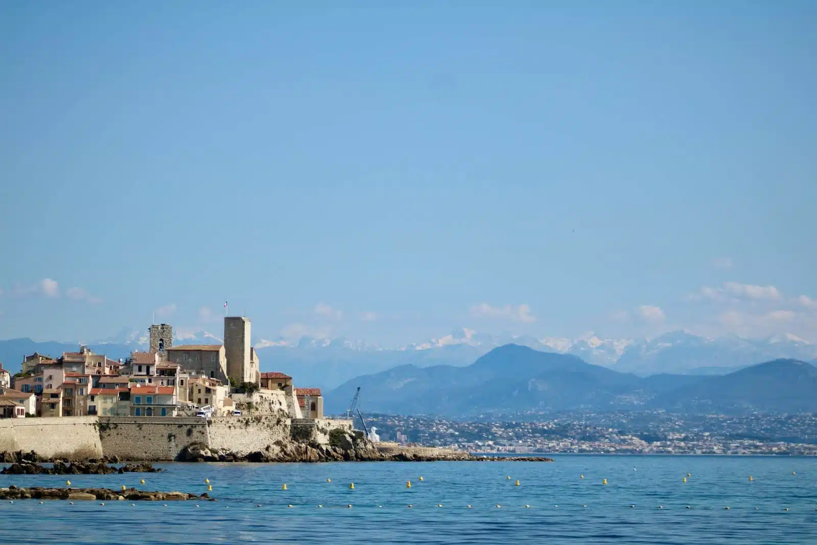 a view of a city from the water with mountains in the background