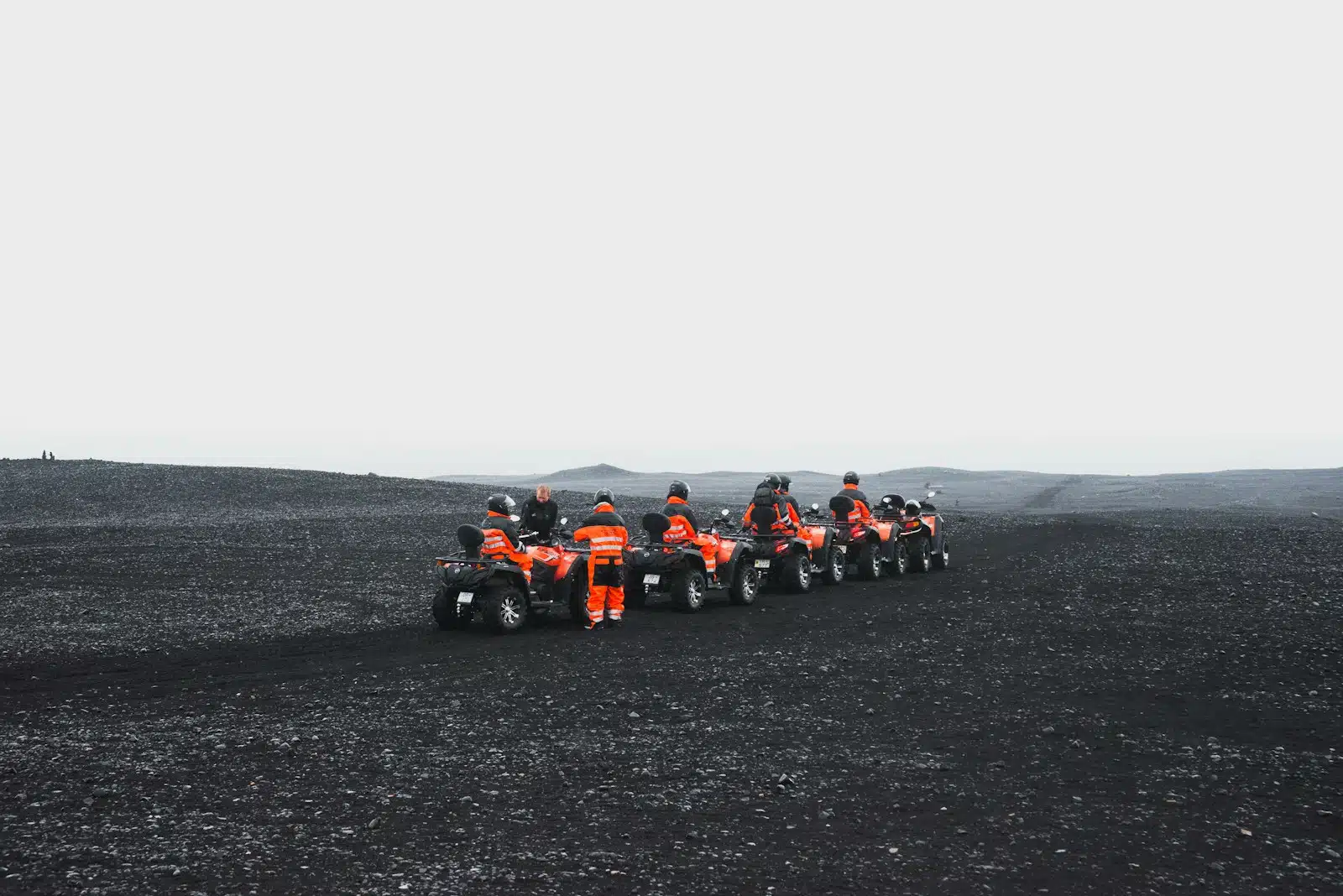 group of people in orange suit riding a ATV