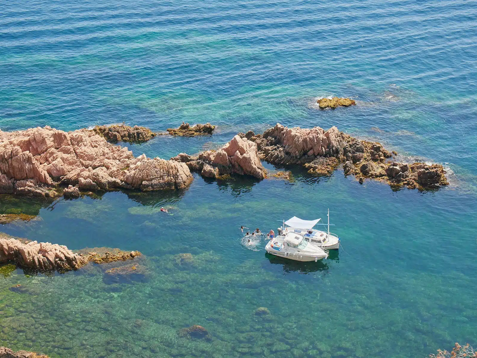 a small boat in the water near some rocks