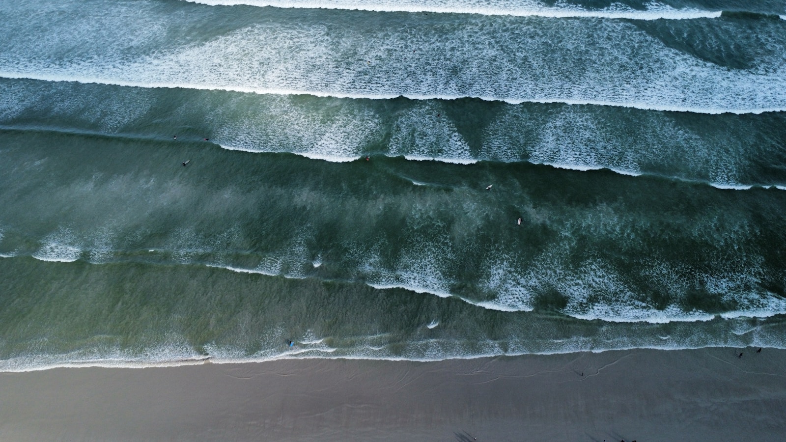 An aerial view of a beach with waves coming in