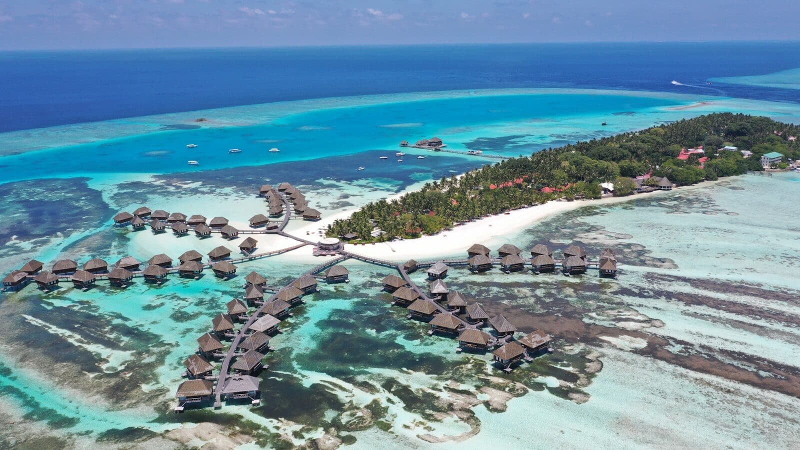 an aerial view of a resort in the middle of the ocean