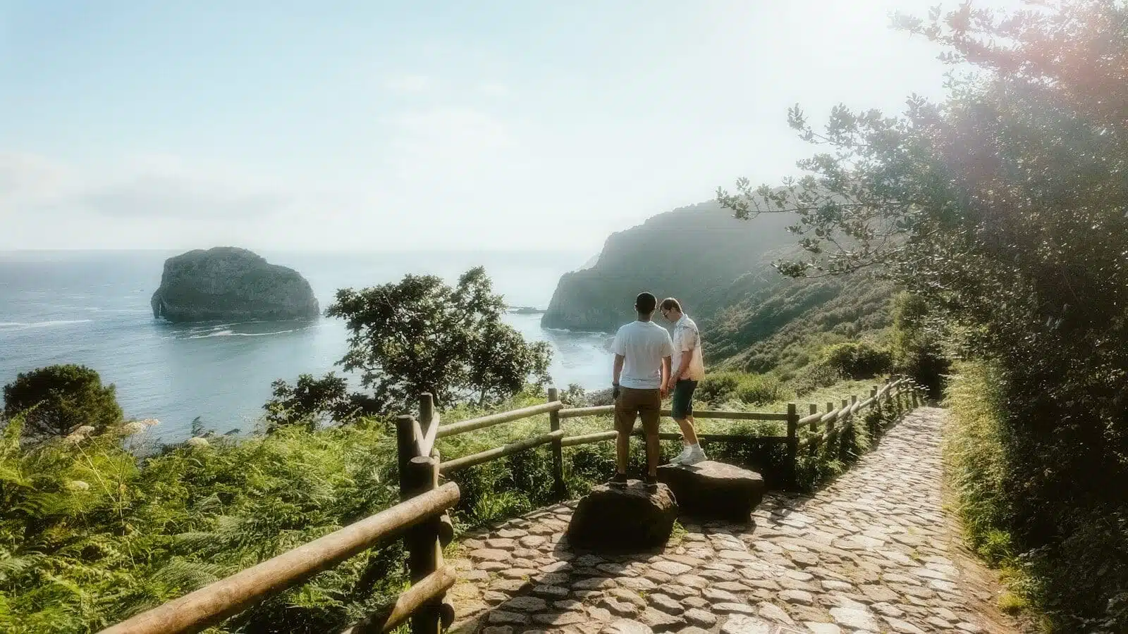 A couple of people that are standing on a hill