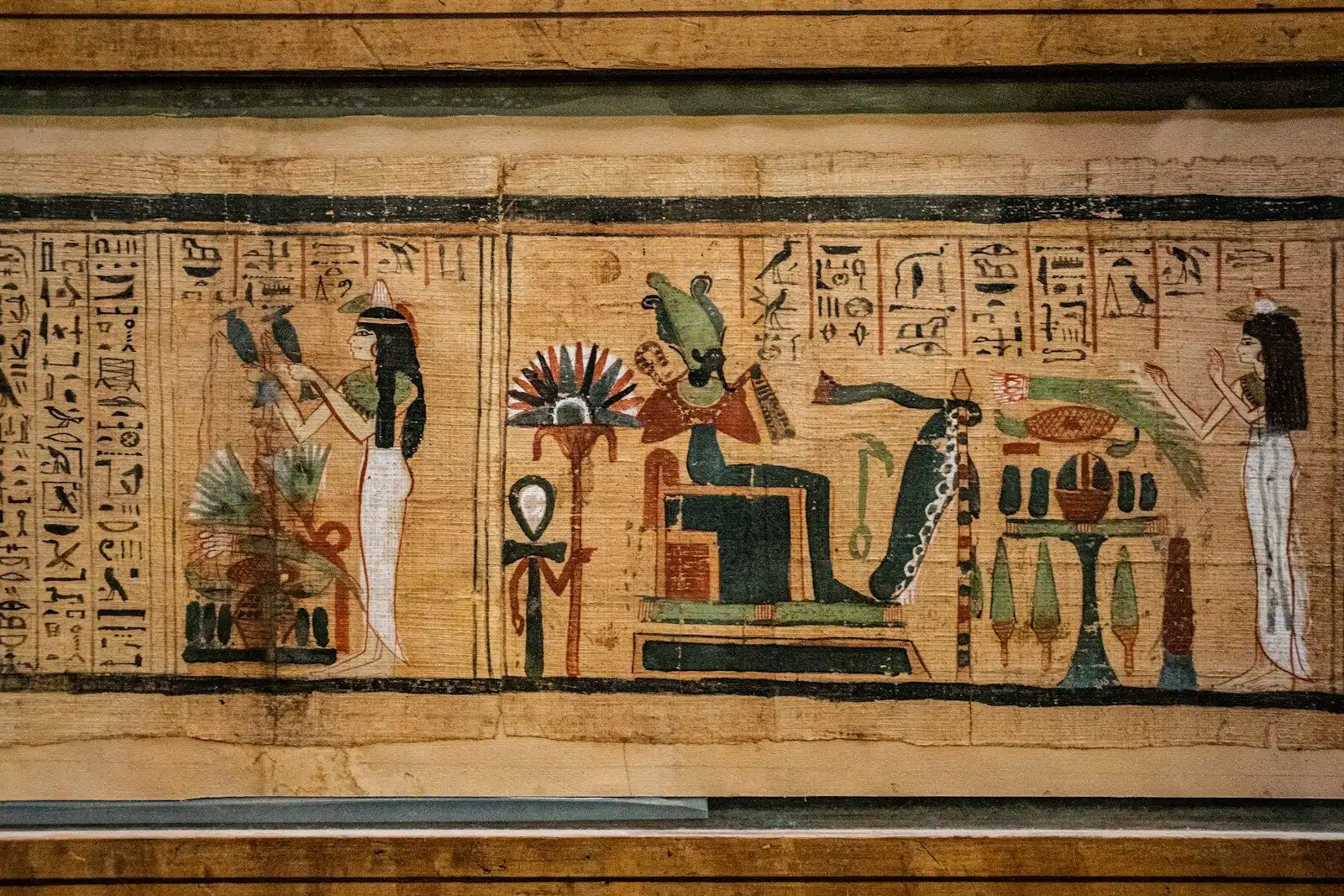 Ancient Egyptian papyrus scroll with painted figures and hieroglyphs in a horizontal frame, valley of the kings tour